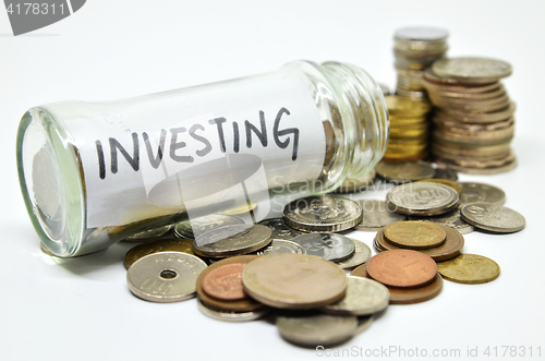 Image of Investment lable in a glass jar with coins spilling out