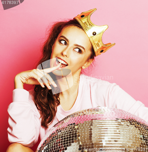 Image of young cute disco girl on pink background with disco ball and cro