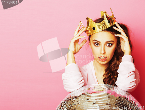 Image of young cute disco girl on pink background with disco ball and cro