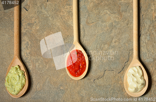 Image of different types of sauces in spoons 