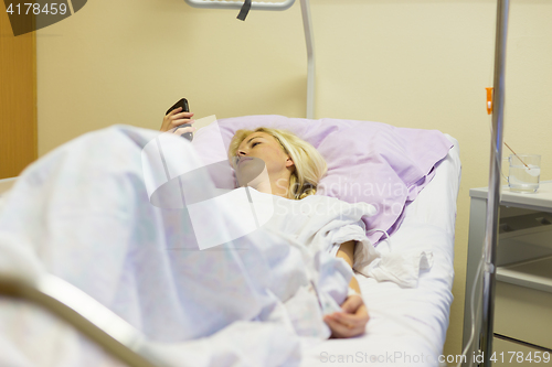 Image of Bedridden female patient recovering after surgery in hospital care.