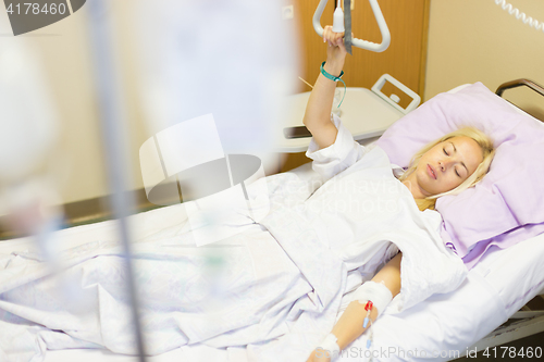 Image of Bedridden female patient recovering after surgery in hospital care.