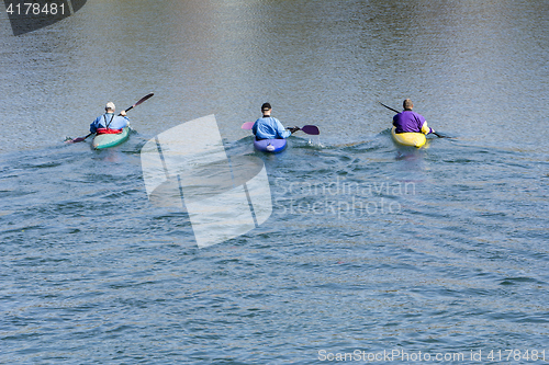 Image of Three rowers with canoe recreate in a lake