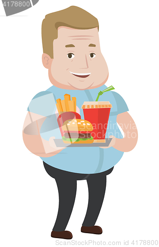 Image of Man holding tray full of fast food.