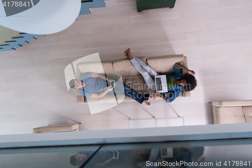 Image of young multiethnic couple relaxes in the living room top view