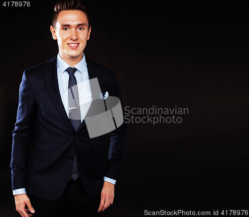 Image of young pretty business man standing on black background, modern h