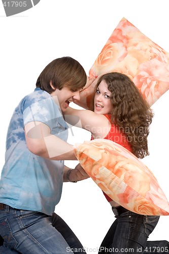 Image of The young couple fights pillows. Isolated