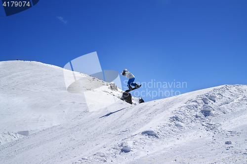 Image of Snowboarder jumping in terrain park at ski resort on sun winter 