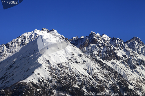 Image of Snowy rocks and blue clear sky at nice winter day