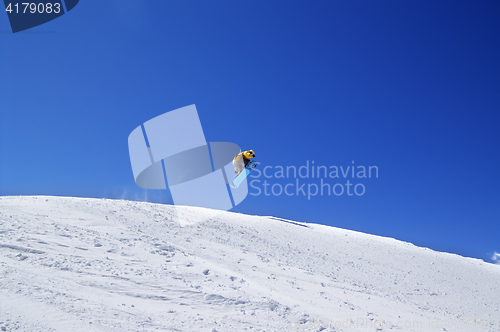 Image of Snowboarder jump in terrain park at ski resort on sun day
