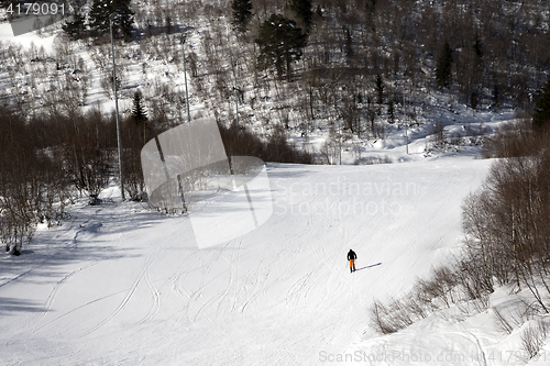 Image of Skier on ski slope at sunny winter day