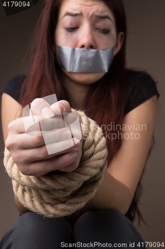 Image of Crying brunette with hands tied