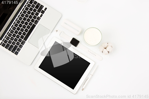 Image of Top view of white office table with laptop