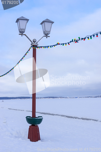 Image of Street lamp on embankment of frozen lake