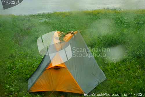 Image of Rainy day. Drops poured glass window and tent of lone camper 1