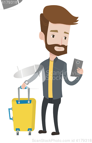 Image of Traveller with suitcase using mobile phone.