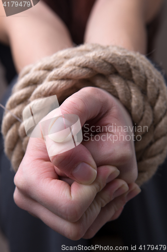 Image of Tied rope hands of woman