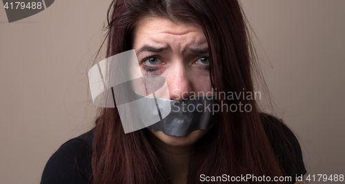 Image of Frightened girl hostage with tape