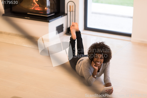 Image of black women used tablet computer on the floor