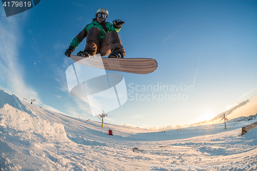 Image of Snowboarder jumping against blue sky