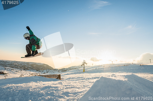 Image of Snowboarder jumping against blue sky