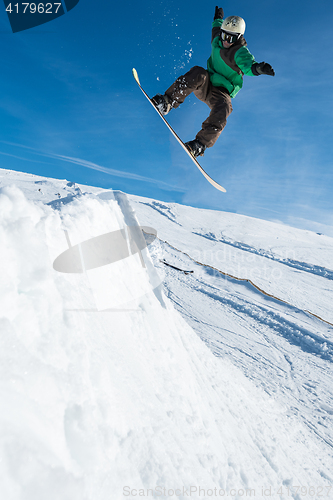 Image of Snowboarder jumping against blue sky