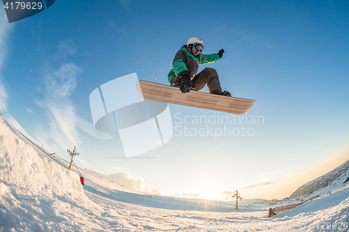 Image of Snowboarder jumping against blue sky