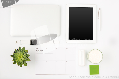 Image of Top view of white office table with laptop