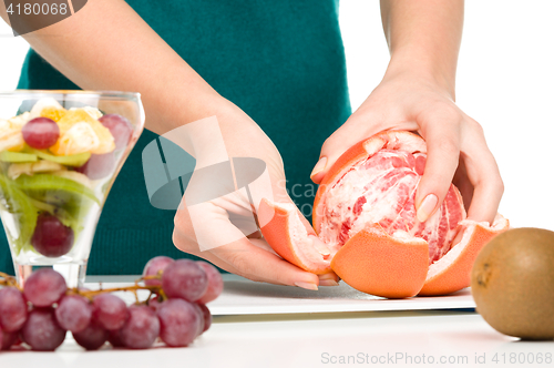 Image of Cook is peeling grapefruit for fruit dessert