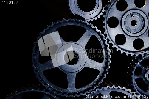 Image of Interlocking industrial  cogwheels top view on black background