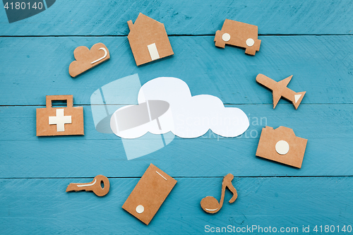 Image of Cardboard web icons  and white cloud on blue background