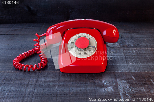 Image of Retro Vintage red landline unhang on wooden background
