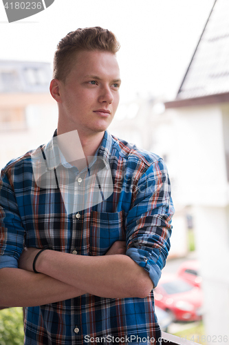 Image of man standing at balcony