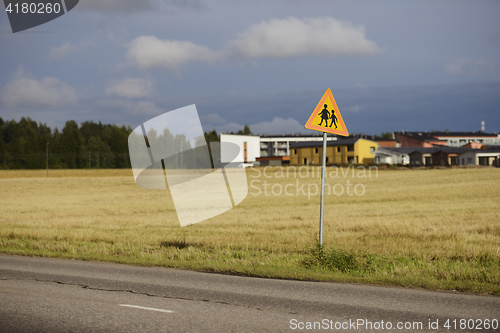 Image of road sign caution children against the town