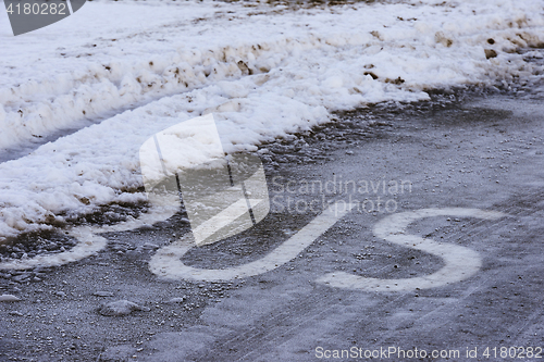 Image of inscription BUS on the icy road surface