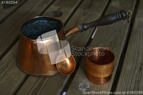 Image of set of copper cookware coffee on wooden table