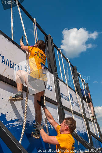 Image of Athletes storm wall in extrim race. Tyumen.Russia