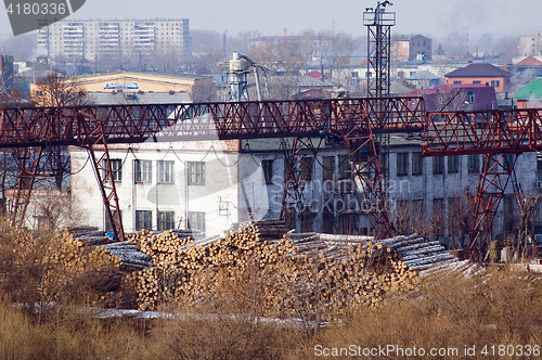 Image of pile of wood logs on plywood combine. Tyumen
