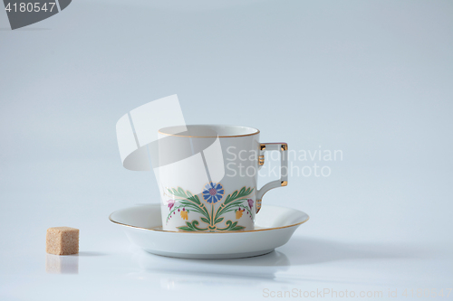 Image of  Beautiful cup with flower and piece of sugar