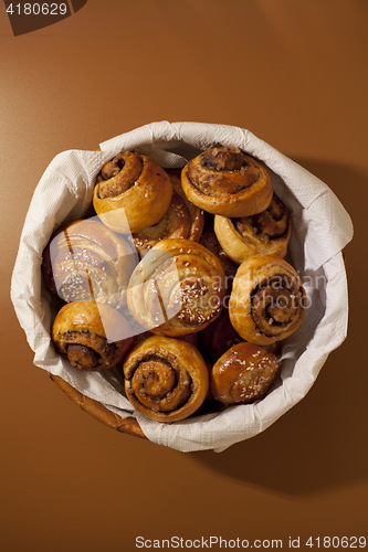 Image of Full basket of sweet bread rolls with cinnamon and sesame seeds 