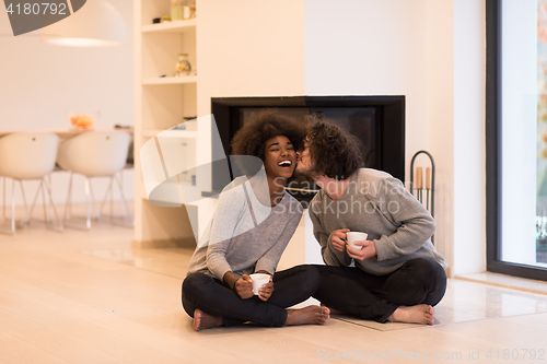 Image of multiethnic couple  in front of fireplace