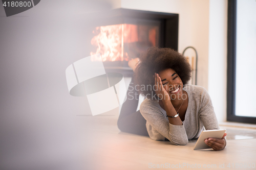 Image of black women used tablet computer on the floor