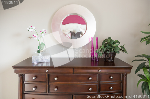 Image of Beautiful Dresser and Mirror Against a Wall in a Home.