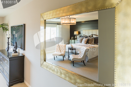 Image of Beautiful Bedroom Reflection in Decorative Mirror.