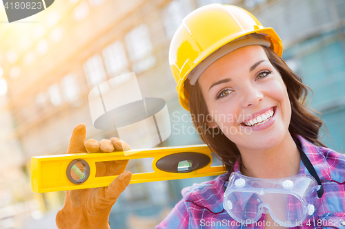 Image of Portrait of Young Female Construction Worker with Level Wearing 