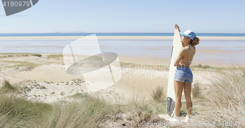 Image of Female with surf admiring waterscape