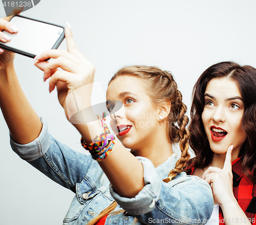 Image of lifestyle people concept: two pretty stylish modern hipster teen girl having fun together, happy smiling making selfie