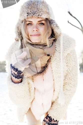 Image of young pretty teenage hipster girl outdoor in winter snow park having fun drinking coffee, warming up happy smiling, lifestyle people concept