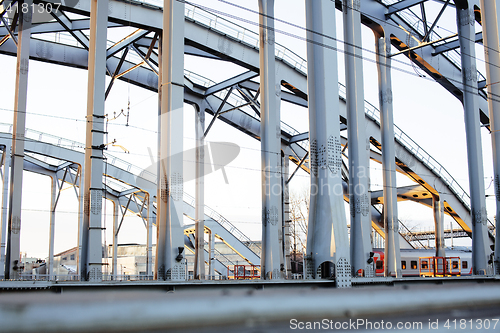 Image of landscape with railway with trains, lot of steel rafters at sunset