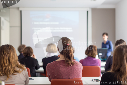 Image of Woman giving presentation in lecture hall at university.